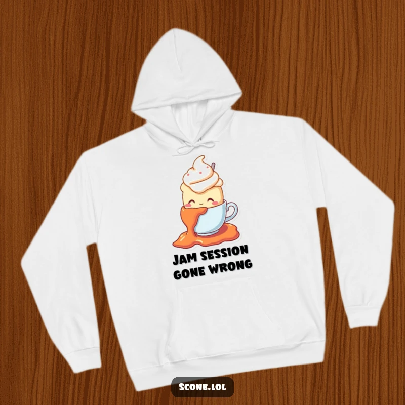 Funny hoodie with a scone character in a teacup hat comically falling on jam, offering warmth and a good dose of humor.