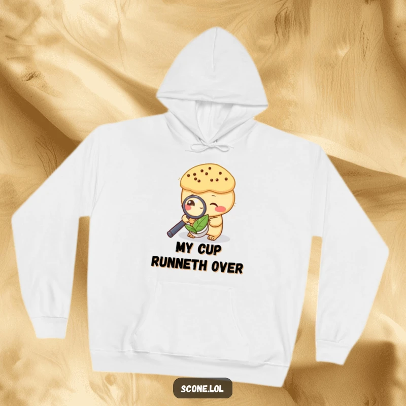 Funny hoodie with a scone investigating a tea leaf under a magnifying glass, ideal for cozy mystery lovers.