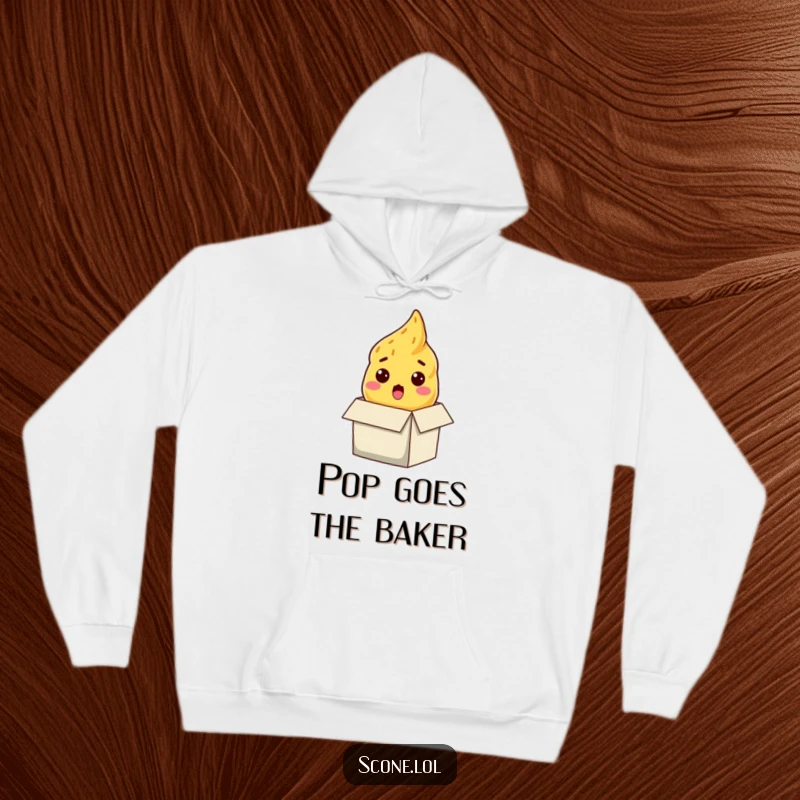 Funny scone hoodie, a surprised baked good emerging from a box, offering warmth and a humorous, startled expression.
