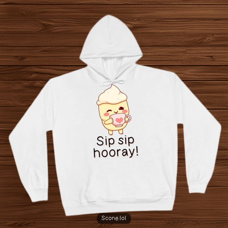 Funny Scone Character Hoodie, winking while holding a miniature teacup, radiating cozy, playful vibes.
