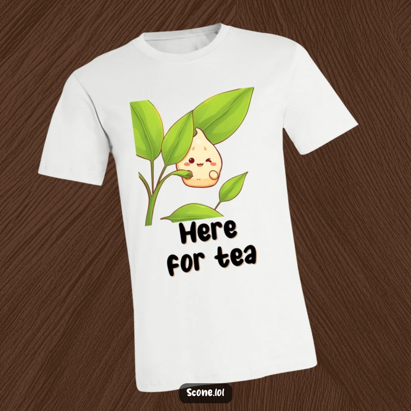 Funny T-Shirt: A scone character with a wide grin peeks out from behind a giant tea leaf, embodying playful mischief.