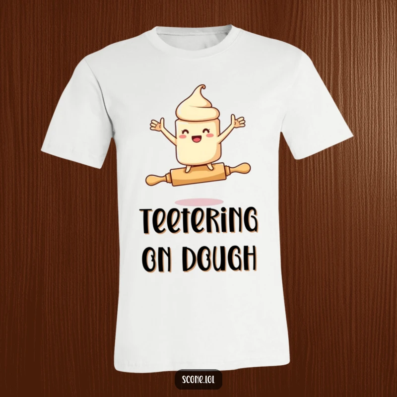Funny t-shirt depicting a scone character losing balance on a rolling pin, arms windmilling comically, conveying a sense of playful panic.